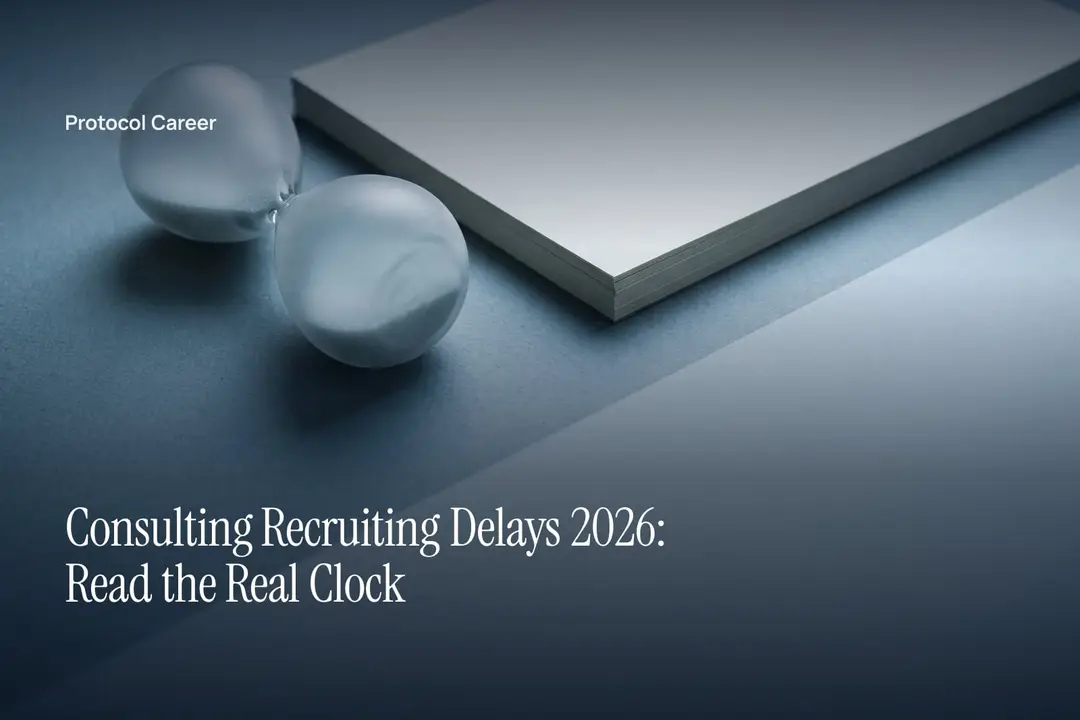 A frosted glass hourglass lying horizontally beside a neat stack of blank paper on a grey surface. Title: “Consulting Recruiting Delays 2026: Read the Real Clock”, over the Protocol Career wordmark.