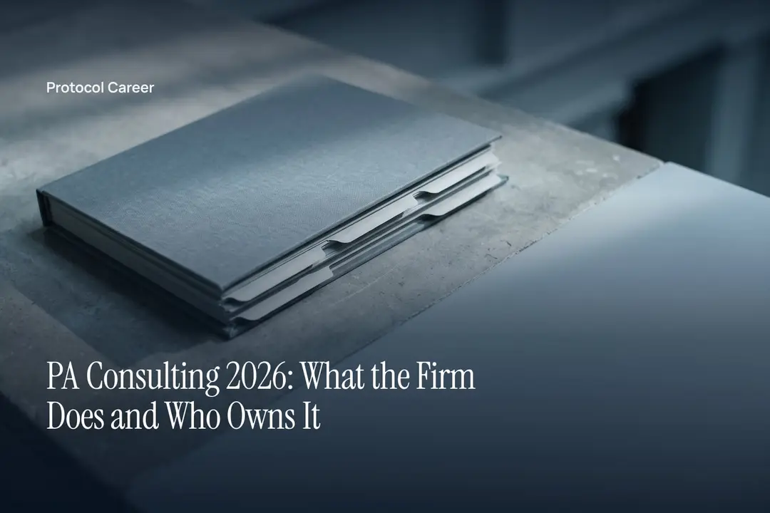 A closed slate-grey dossier with blank tabs sits on a neutral stone surface under soft lighting. Title: “PA Consulting 2026: What the Firm Does and Who Owns It”, over the Protocol Career wordmark.