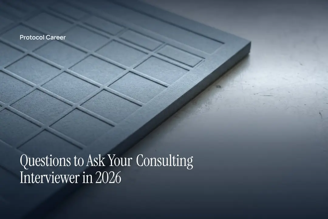 A blank grey card with debossed grid lines rests on a smooth, softly lit stone surface. Title: “Questions to Ask Your Consulting Interviewer in 2026”, over the Protocol Career wordmark.