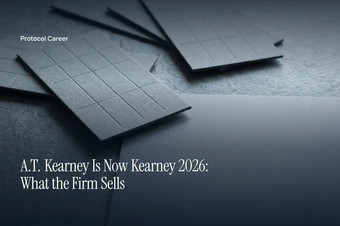 Thick, textless grey cardstock sheets with debossed grid patterns lie on a smooth, empty stone surface. Title: “A.T. Kearney Is Now Kearney 2026: What the Firm Sells”, over the Protocol Career wordmark.