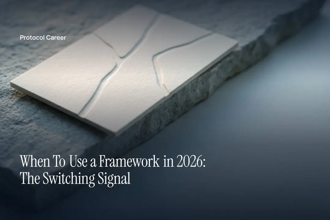 An ivory card debossed with two uneven branching tracks rests on a matte stone surface in soft light. Title: “When To Use a Framework in 2026: The Switching Signal”, over the Protocol Career wordmark.